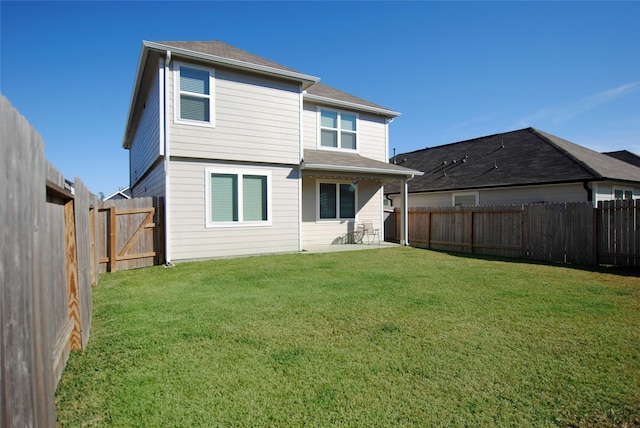 rear view of property with a yard and a patio