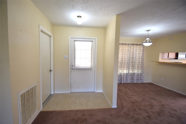 entryway featuring a textured ceiling and carpet flooring