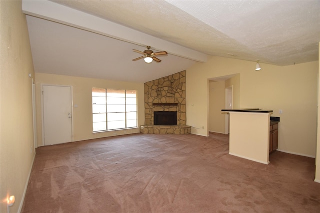 unfurnished living room featuring ceiling fan, a fireplace, vaulted ceiling with beams, carpet flooring, and a textured ceiling