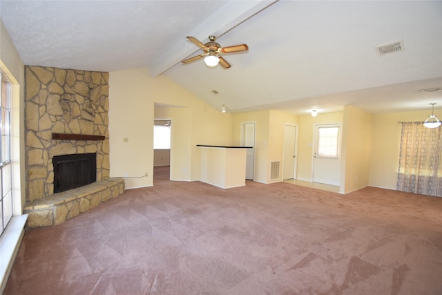 unfurnished living room with ceiling fan, vaulted ceiling with beams, carpet floors, and a fireplace