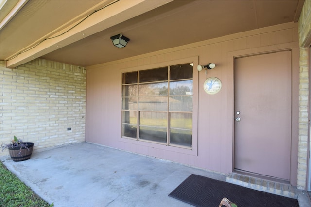 view of exterior entry featuring a patio area