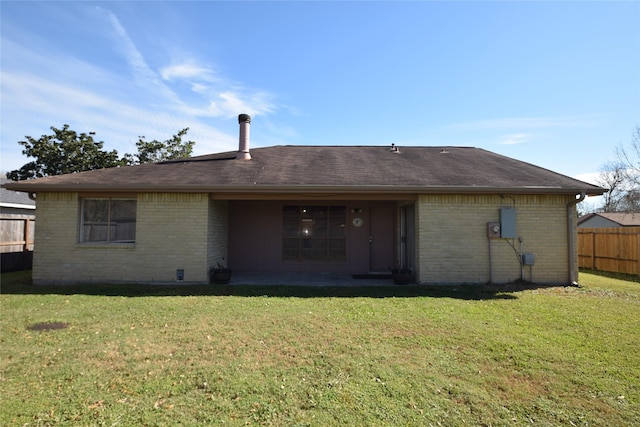 back of property featuring a patio area and a yard