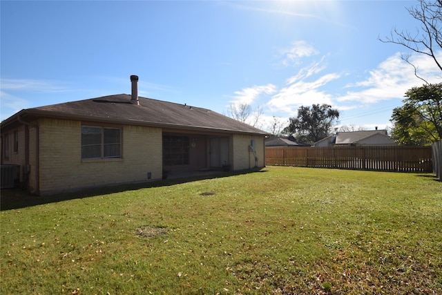 back of house featuring a yard and central air condition unit