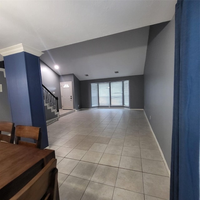 tiled living room featuring vaulted ceiling and ornamental molding