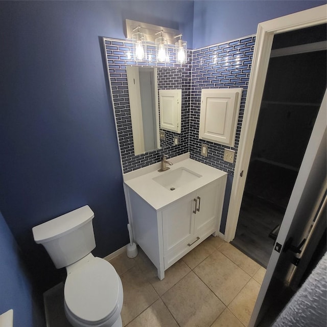 bathroom with toilet, vanity, tasteful backsplash, and tile patterned floors