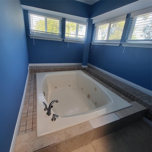 bathroom with tile patterned flooring and tiled bath