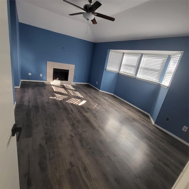 unfurnished living room with lofted ceiling, a tile fireplace, ceiling fan, and dark hardwood / wood-style floors