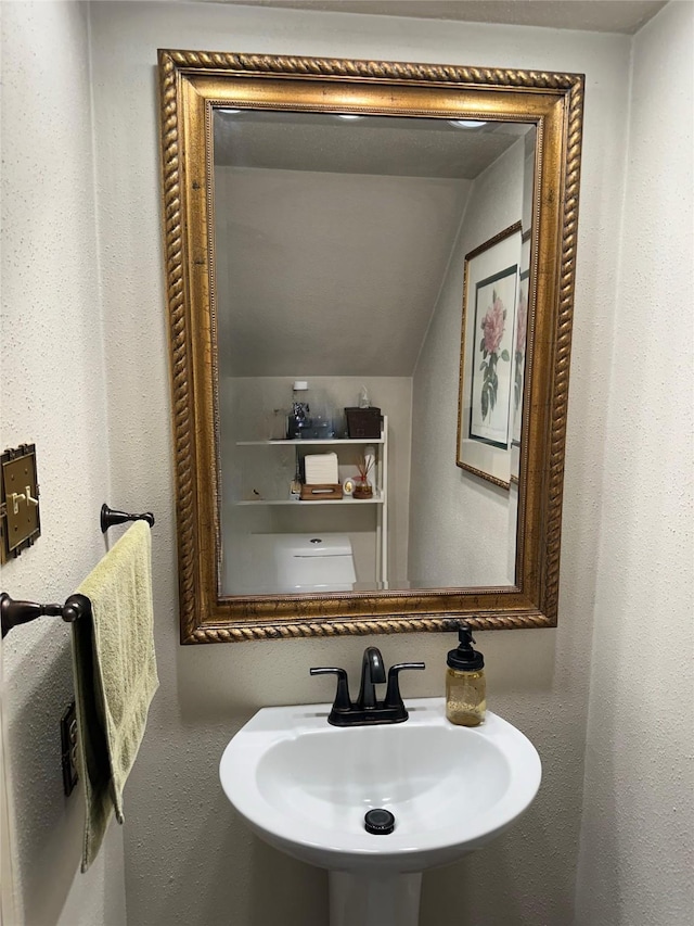 bathroom with sink and vaulted ceiling