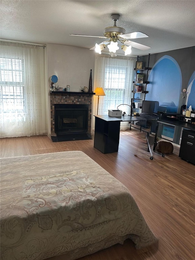 bedroom featuring hardwood / wood-style floors, a textured ceiling, and ceiling fan