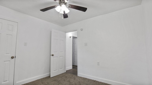 unfurnished bedroom featuring ceiling fan and dark colored carpet