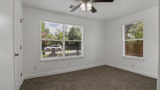 empty room featuring ceiling fan and dark carpet