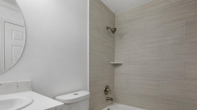 full bathroom featuring vanity, tiled shower / bath combo, and toilet