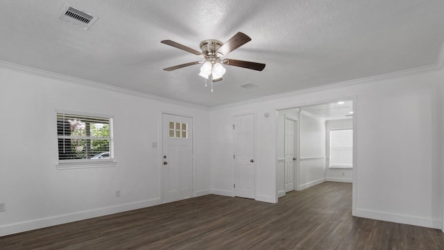 empty room featuring ceiling fan, a healthy amount of sunlight, ornamental molding, and dark wood-type flooring