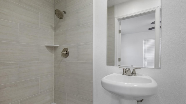 bathroom with a tile shower and sink