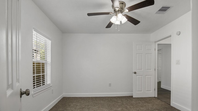 unfurnished room with dark colored carpet and ceiling fan