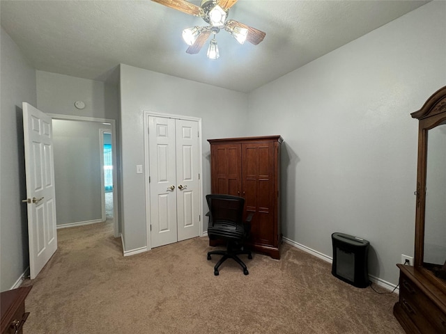 carpeted home office featuring ceiling fan