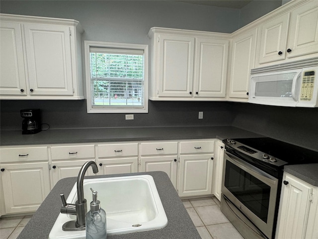 kitchen featuring light tile patterned flooring, white cabinetry, stainless steel range with electric cooktop, and sink