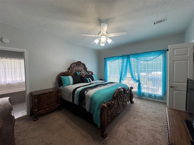 bedroom with ceiling fan, carpet floors, and a textured ceiling