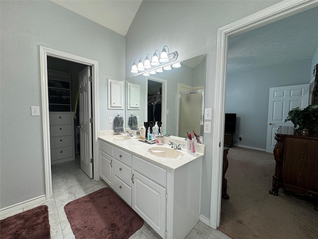 17 Cottonwood Rd, Trinity, TX 75862 - full bath featuring a spacious closet, double vanity, lofted ceiling, a shower stall, and baseboards
