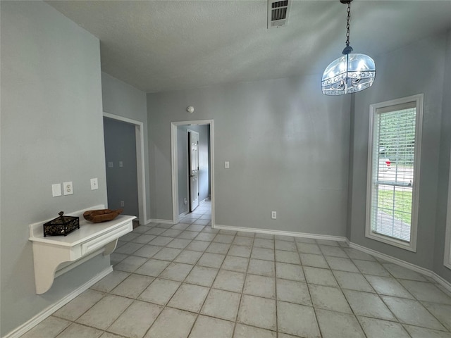 17 Cottonwood Rd, Trinity, TX 75862 - spare room featuring light tile patterned floors, baseboards, a textured ceiling, and a chandelier