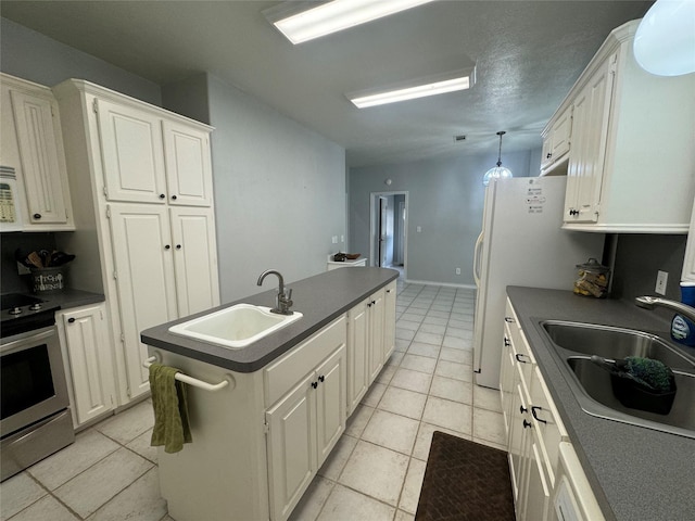 kitchen featuring light tile patterned floors, white cabinetry, sink, and stainless steel stove