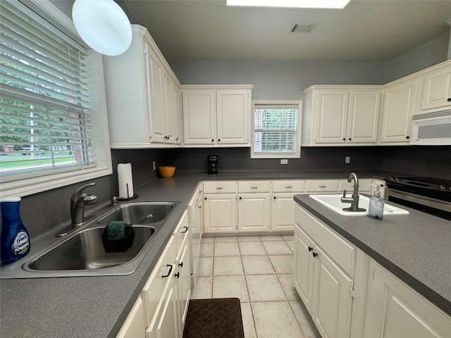 kitchen with white cabinets, electric range oven, light tile patterned flooring, and sink