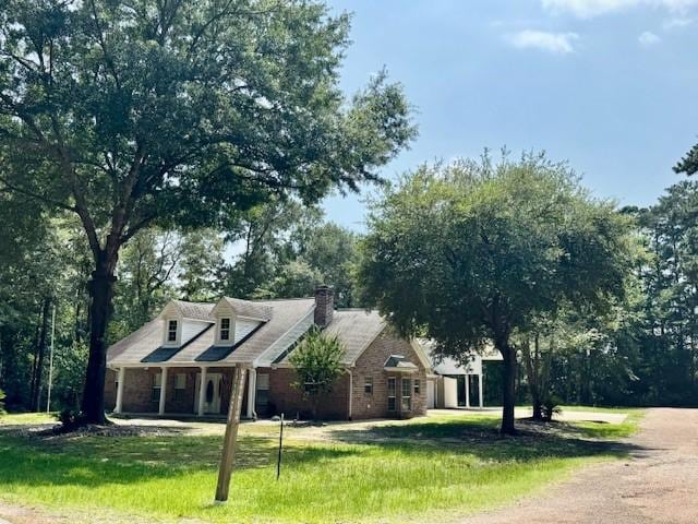 17 Cottonwood Rd, Trinity, TX 75862 - view of front facade featuring a front lawn, a chimney, brick siding, and a porch