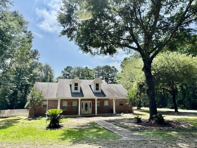 17 Cottonwood Rd, Trinity, TX 75862 - cape cod-style house with brick siding, covered porch, and a chimney