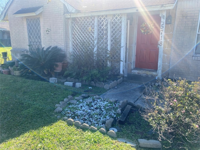 entrance to property with a lawn