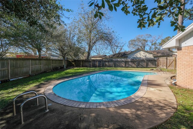 view of swimming pool with a lawn