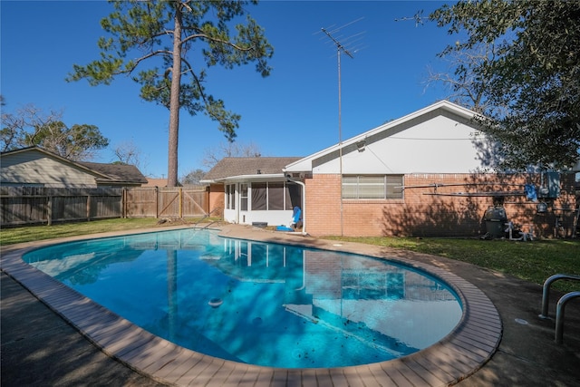 view of pool featuring a sunroom and a lawn