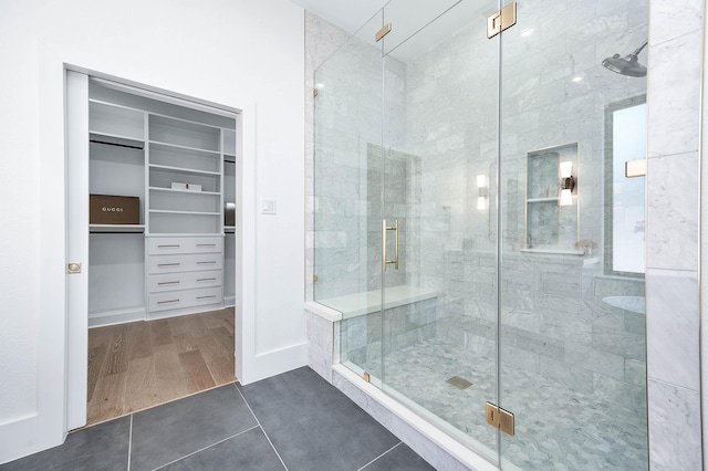 bathroom with hardwood / wood-style flooring and a shower with shower door