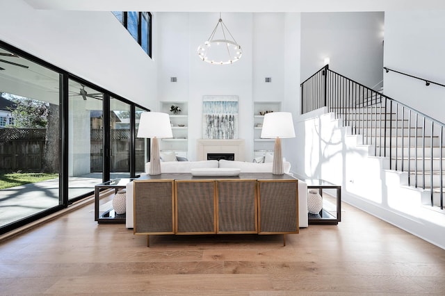 living room featuring light hardwood / wood-style floors, an inviting chandelier, and a healthy amount of sunlight