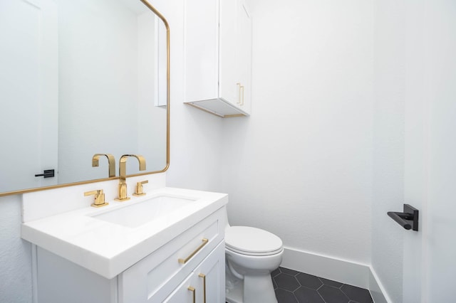 bathroom featuring tile patterned flooring, vanity, and toilet