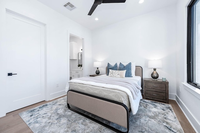 bedroom featuring hardwood / wood-style flooring, ensuite bath, and ceiling fan