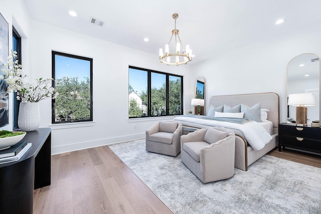 bedroom featuring a chandelier and light hardwood / wood-style floors