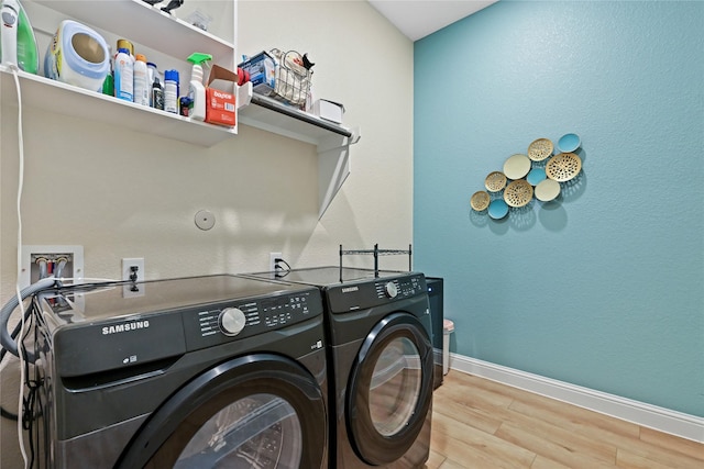 laundry room featuring wood-type flooring and separate washer and dryer