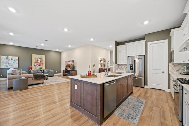 kitchen featuring sink, stainless steel appliances, a kitchen island with sink, dark brown cabinets, and white cabinets