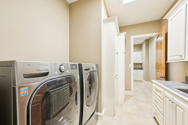 laundry room with washer and clothes dryer and cabinets