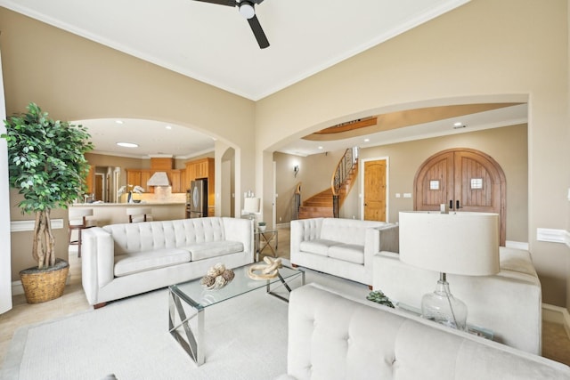 living room with ornamental molding, light tile patterned flooring, and ceiling fan