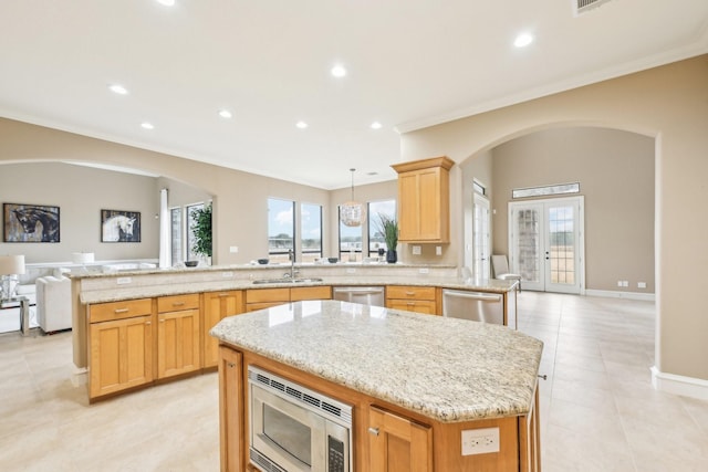 kitchen with a spacious island, stainless steel appliances, sink, and hanging light fixtures