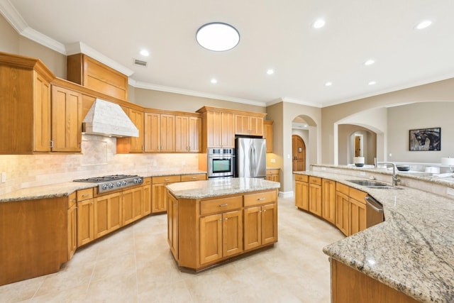 kitchen featuring sink, a center island, stainless steel appliances, light stone countertops, and custom range hood