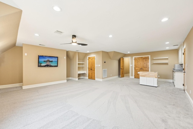 unfurnished living room featuring ceiling fan, vaulted ceiling, and light carpet