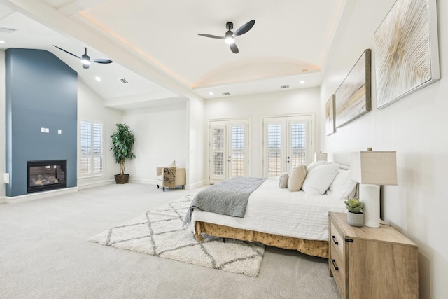 bedroom with french doors, multiple windows, vaulted ceiling, and carpet