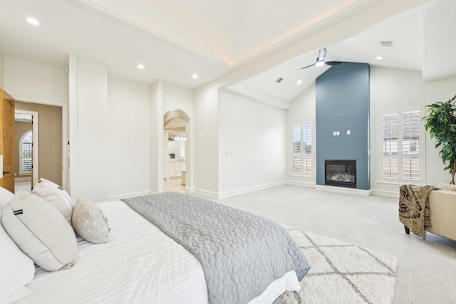 bedroom with light colored carpet, high vaulted ceiling, and multiple windows