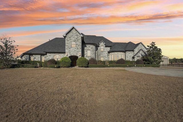 french country inspired facade with a lawn