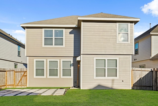 rear view of house featuring a lawn