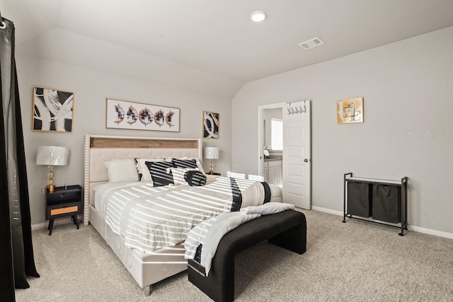 carpeted bedroom with ensuite bathroom and lofted ceiling