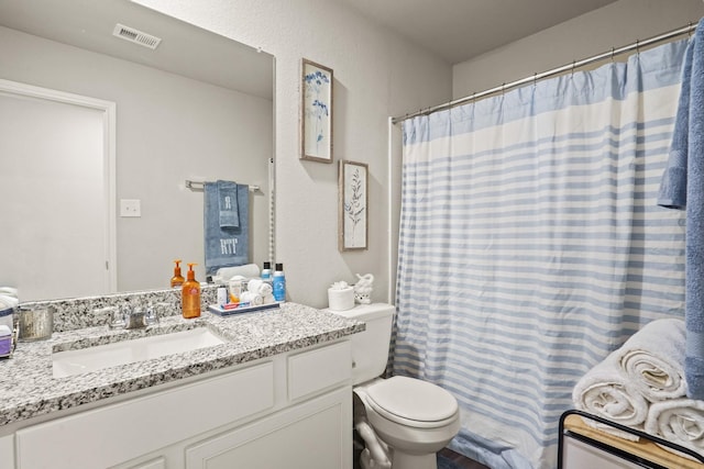 bathroom featuring vanity, toilet, and walk in shower