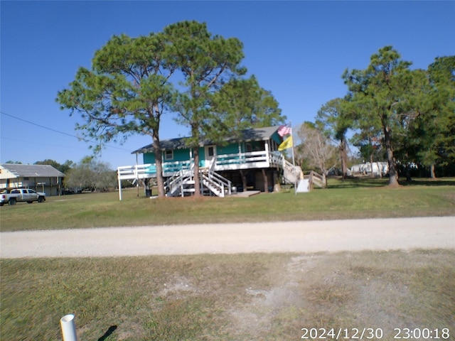 view of front of home with a deck and a front lawn